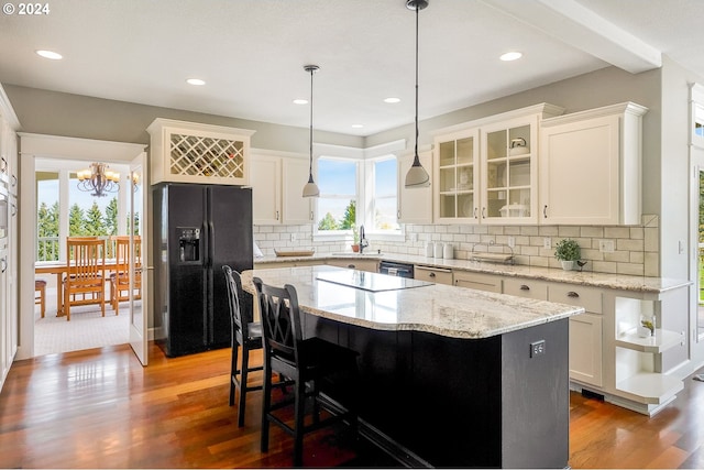 kitchen featuring an inviting chandelier, white cabinets, black appliances, and a kitchen island