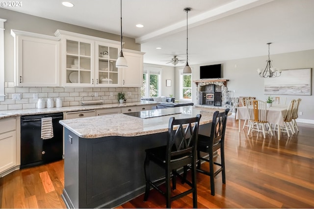 kitchen featuring white cabinets, a fireplace, backsplash, and black appliances