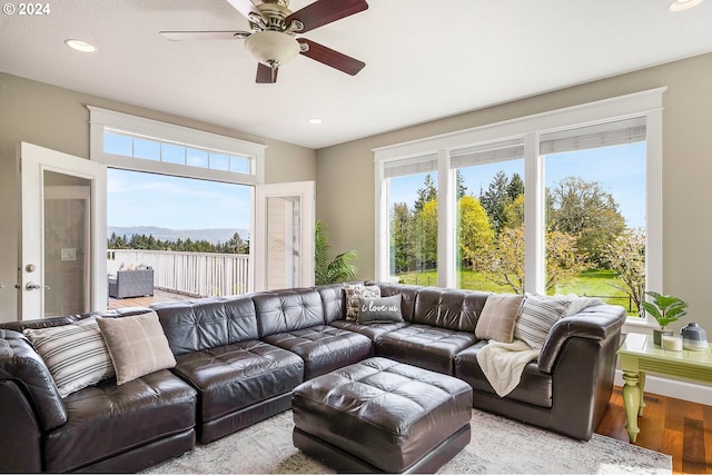 living room featuring ceiling fan, light wood-type flooring, french doors, and a healthy amount of sunlight