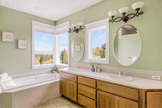 bathroom featuring tiled tub, vanity, and tile patterned floors