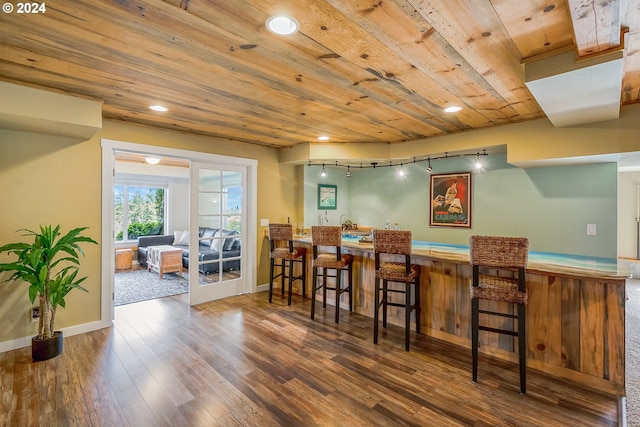 dining room with wood ceiling, indoor bar, and dark wood-type flooring