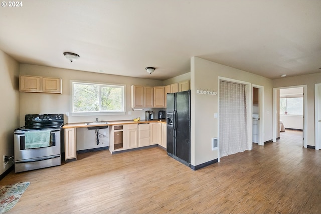 kitchen with stainless steel range with electric cooktop, light hardwood / wood-style flooring, black fridge, and light brown cabinetry