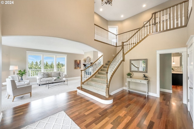 interior space featuring a towering ceiling and hardwood / wood-style floors