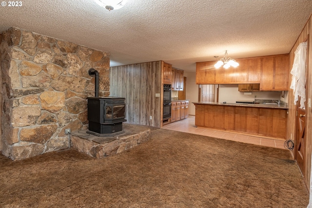 kitchen with light carpet, hanging light fixtures, a chandelier, and black double oven