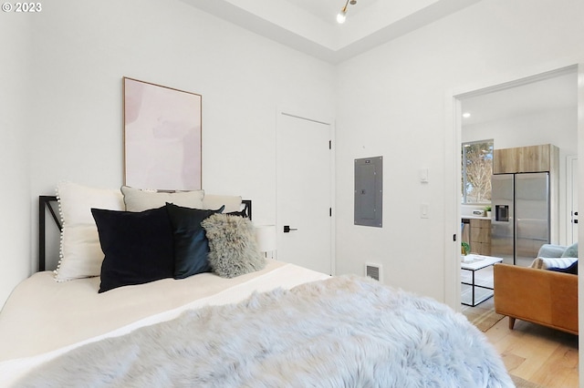 bedroom featuring high quality fridge and light hardwood / wood-style flooring