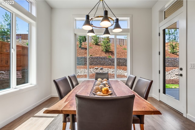 dining area with baseboards and wood finished floors