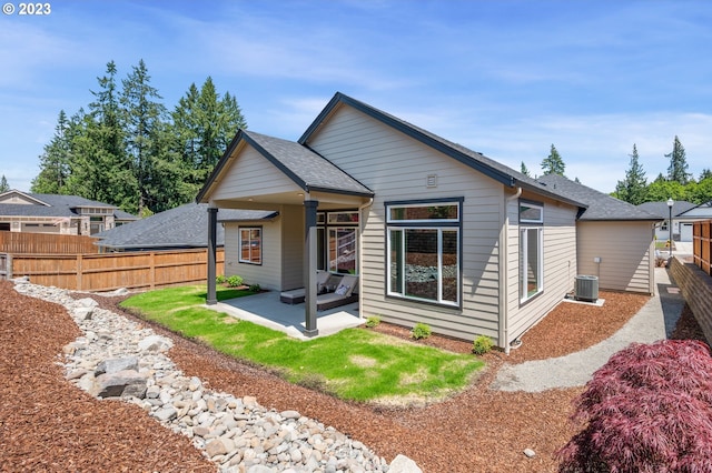 back of property with a patio, central AC, fence, and roof with shingles