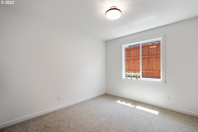 unfurnished room featuring baseboards and carpet flooring