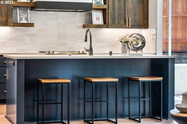 bar featuring range hood and tasteful backsplash