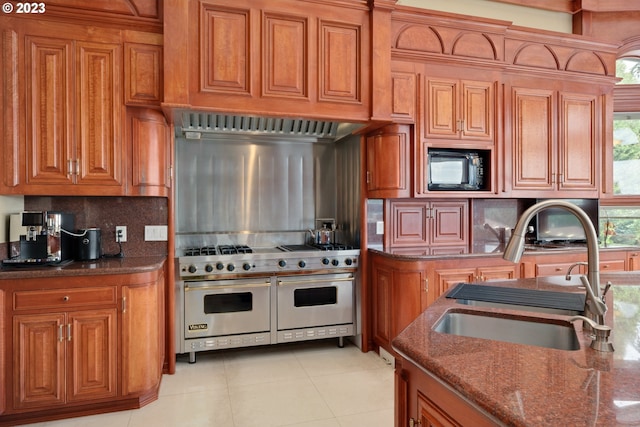 kitchen featuring tasteful backsplash, black microwave, range with two ovens, sink, and light tile flooring