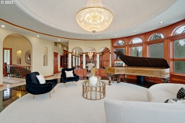 living room with an inviting chandelier, a raised ceiling, and hardwood / wood-style flooring