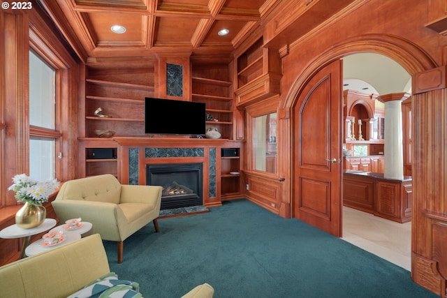 carpeted living room with coffered ceiling, a high end fireplace, built in features, and decorative columns