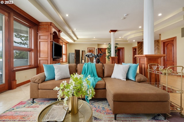 tiled living room featuring ornate columns and a raised ceiling