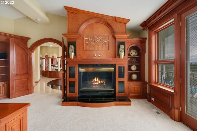 carpeted living room featuring a tiled fireplace and vaulted ceiling