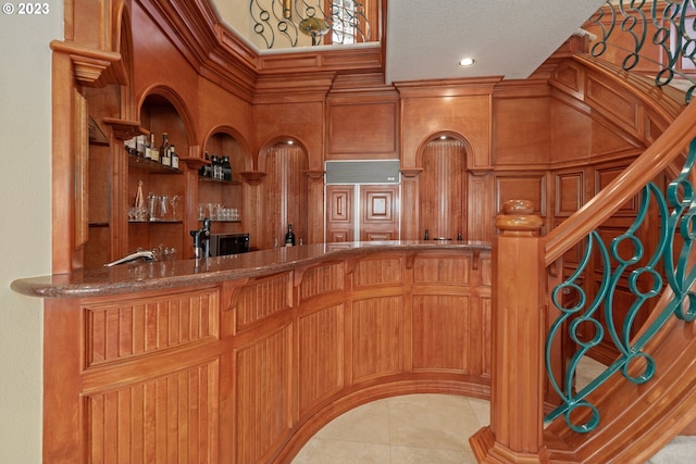 interior space with pendant lighting, dark stone counters, and light tile floors