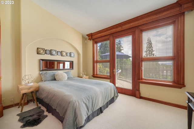 bedroom featuring lofted ceiling, light carpet, and access to exterior