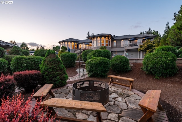 patio terrace at dusk featuring an outdoor fire pit