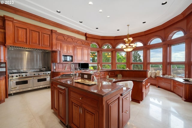 kitchen with a center island with sink, a notable chandelier, black microwave, range with two ovens, and sink