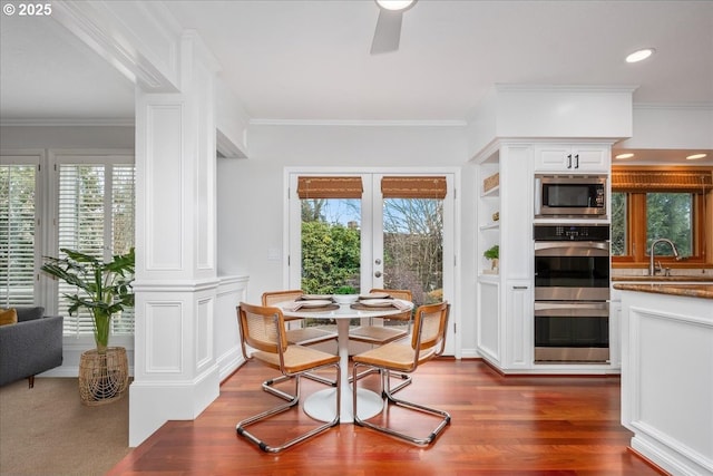 dining room with a wealth of natural light, ornamental molding, dark wood-style flooring, and ceiling fan