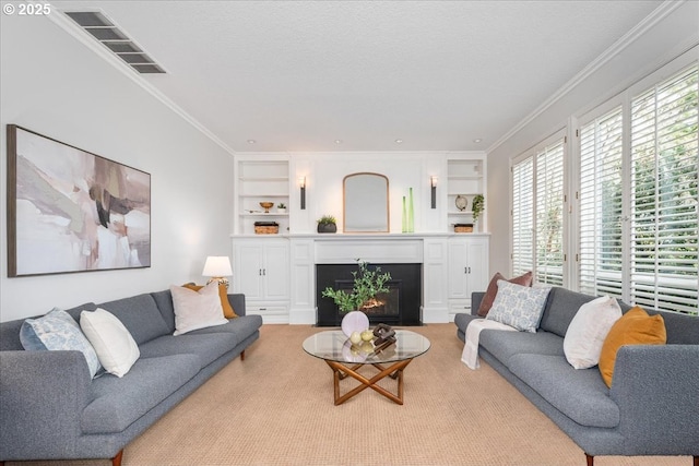 living area featuring a fireplace with flush hearth, built in shelves, visible vents, and crown molding