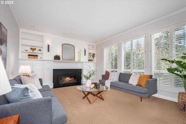 carpeted living room with a glass covered fireplace, a wealth of natural light, built in shelves, and crown molding