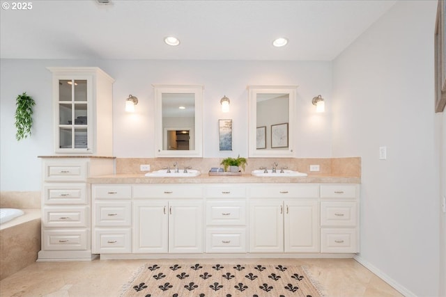 bathroom with a tub, double vanity, a sink, and backsplash
