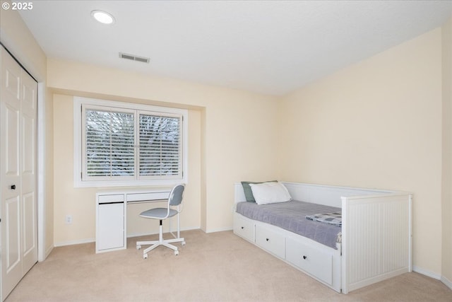 bedroom with light carpet, visible vents, and baseboards