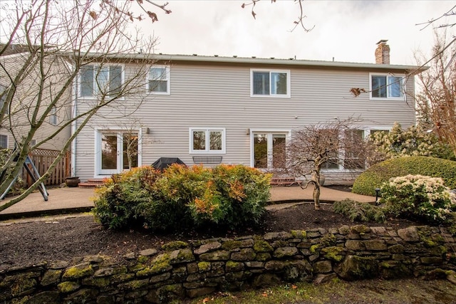 rear view of house with a patio area, entry steps, a chimney, and fence