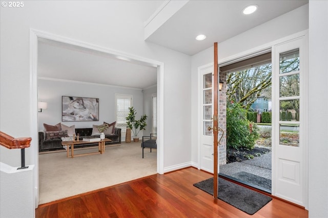 entryway featuring dark wood finished floors, recessed lighting, crown molding, dark colored carpet, and baseboards