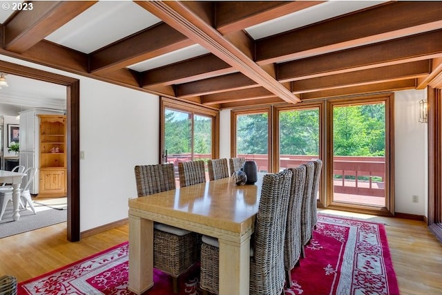 dining space with light hardwood / wood-style flooring, coffered ceiling, and beamed ceiling