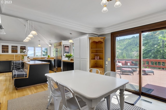 dining room featuring vaulted ceiling, light hardwood / wood-style floors, and a notable chandelier