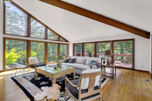 living room with high vaulted ceiling, light hardwood / wood-style floors, and beamed ceiling