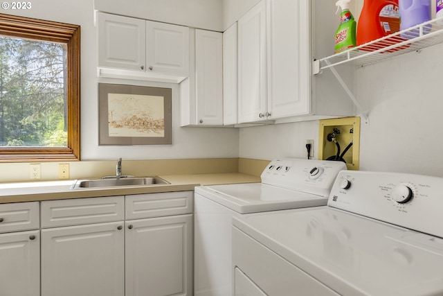 laundry room with washer and dryer, cabinets, sink, and a wealth of natural light