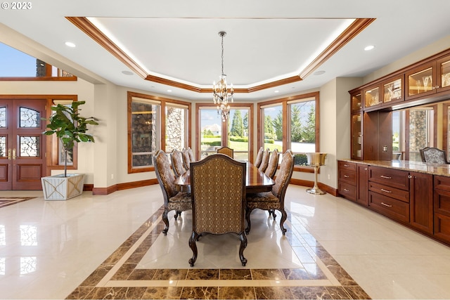 tiled dining area featuring crown molding, a notable chandelier, and a raised ceiling