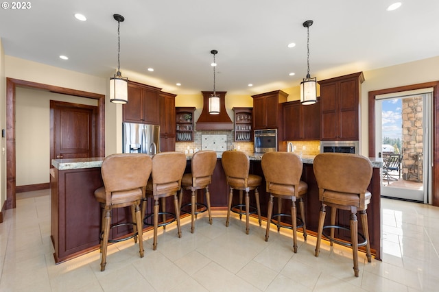 kitchen featuring stainless steel appliances, custom exhaust hood, a breakfast bar area, backsplash, and hanging light fixtures