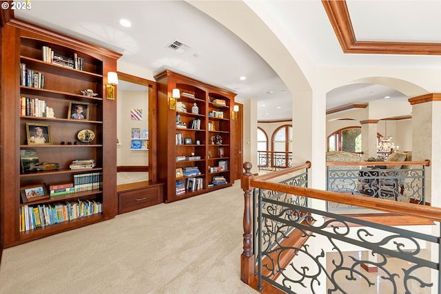 hall featuring light colored carpet and crown molding