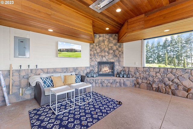 living room with concrete flooring, lofted ceiling, a stone fireplace, and wooden ceiling