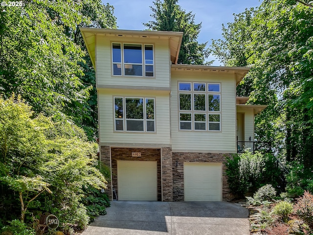 5912 SW Yamhill St, Portland, OR 97221 - view of front of house featuring stone siding, concrete driveway, and an attached garage