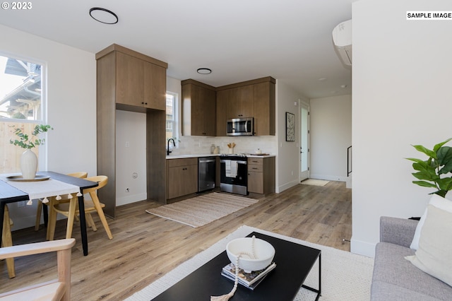 kitchen featuring appliances with stainless steel finishes, a healthy amount of sunlight, and light hardwood / wood-style flooring