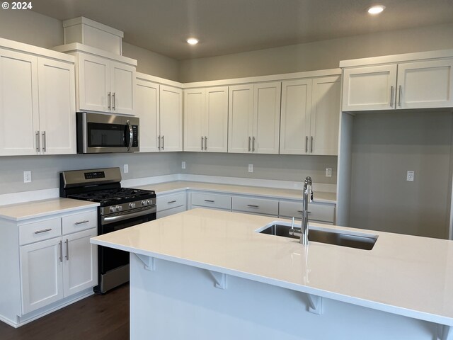 kitchen featuring sink, white cabinetry, dark hardwood / wood-style flooring, a kitchen island with sink, and appliances with stainless steel finishes