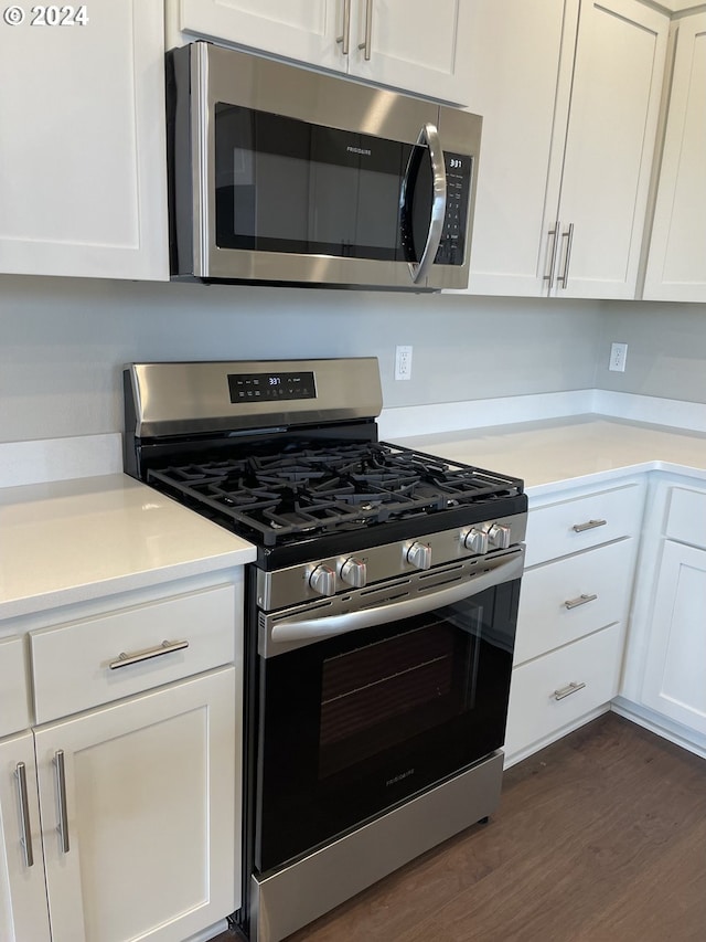 kitchen featuring white cabinets, dark hardwood / wood-style flooring, and stainless steel appliances