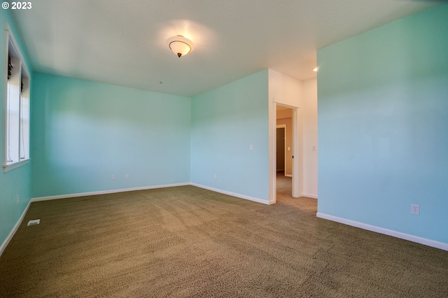 unfurnished room featuring dark colored carpet