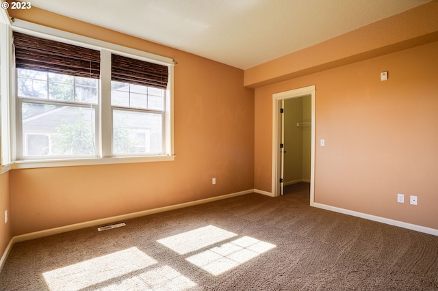 spare room with dark carpet