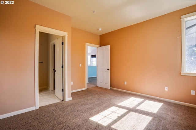 unfurnished bedroom featuring light carpet