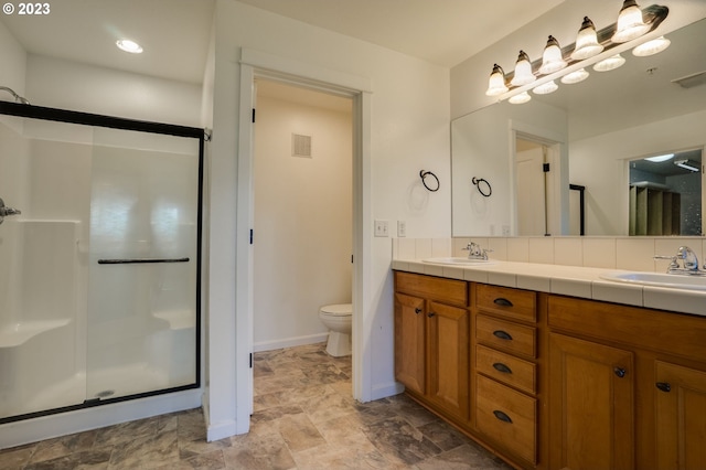 bathroom featuring double sink vanity, tile floors, toilet, and an enclosed shower