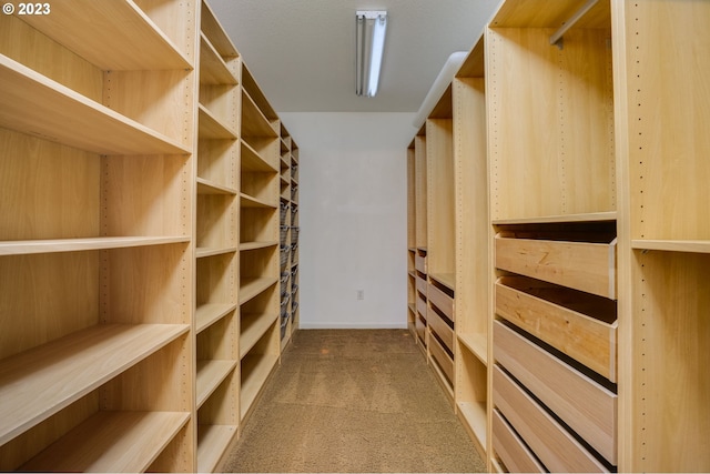 walk in closet featuring dark carpet