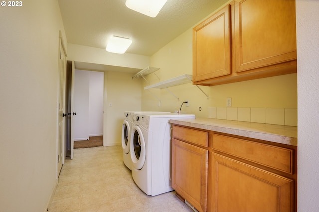 laundry area with light tile floors, washing machine and dryer, and cabinets