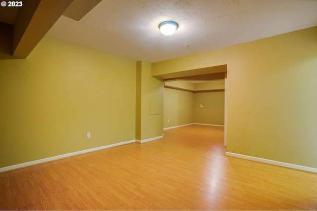 empty room featuring a textured ceiling and light wood-type flooring