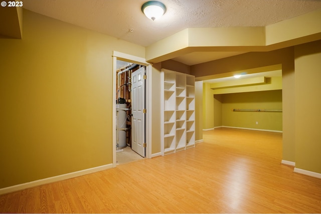 empty room with a textured ceiling and light hardwood / wood-style floors