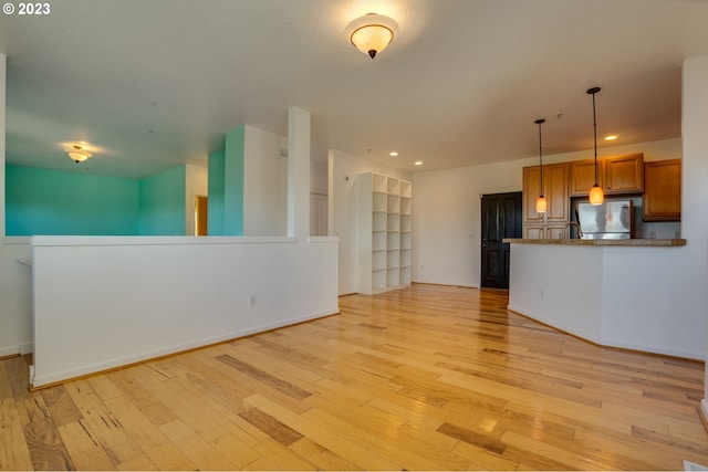 unfurnished living room with built in features and light wood-type flooring